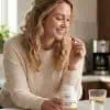 Woman in her kitchen taking Curcumin anti-inflammatory formula.